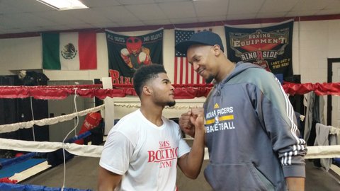 Local boxer Anthony Sims at his gym, mugging with David West.